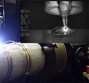 A close-up image showing a welding process. The top section displays monitoring parameters with a nozzle working on a metal surface. The lower section shows a large cylindrical metal object secured in place.